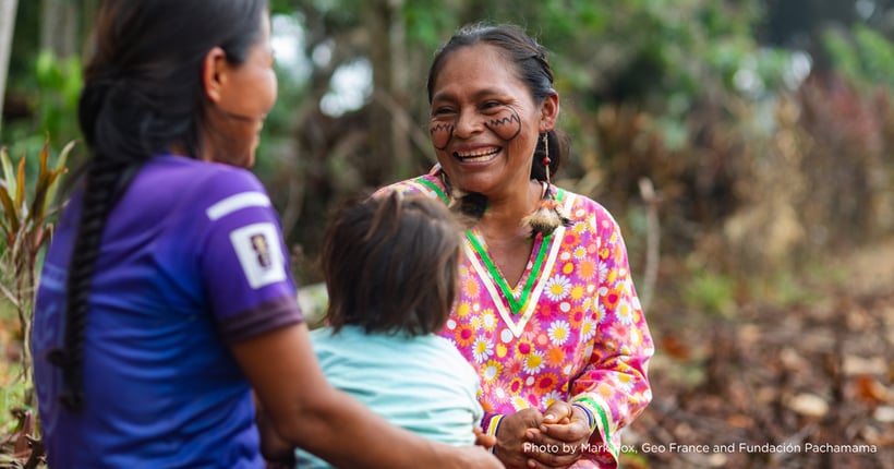 2 Indigenous women and a baby having a conversation