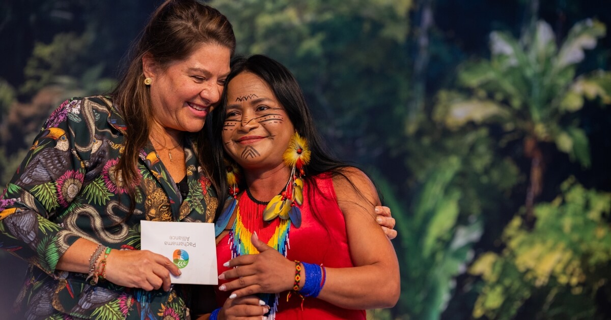 Belen and Narcisa hugging on stage