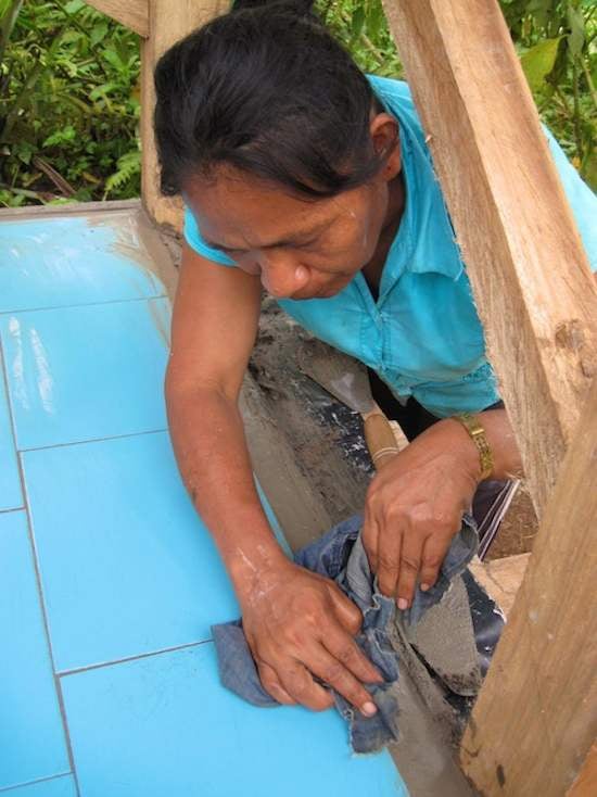 Achuar woman puts the finishing touches on an ecological dry toilet