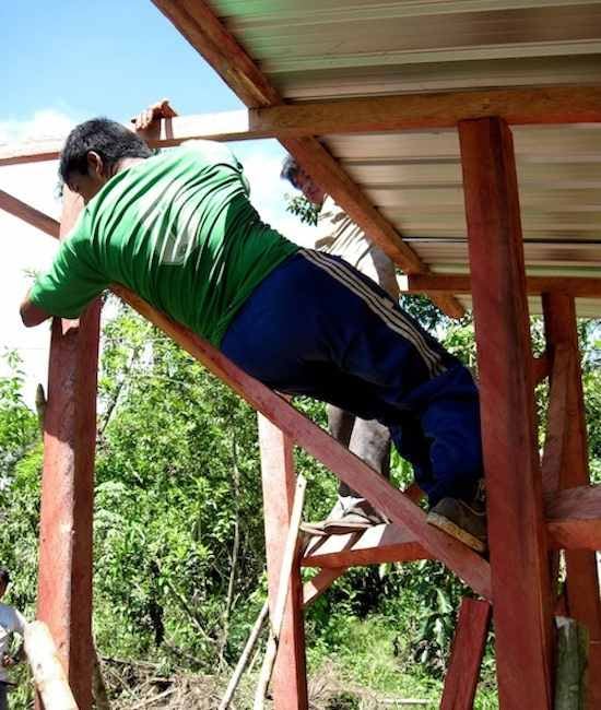 Achuar man building frame for ecological dry toilet